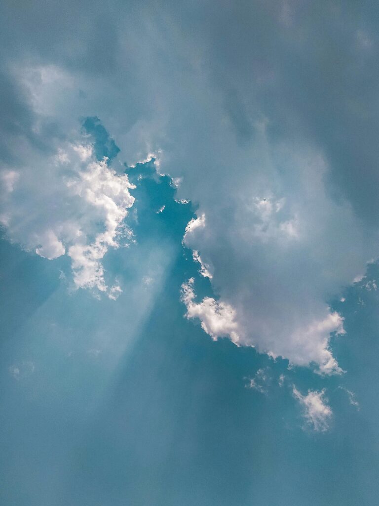 pexels-photo-3783385-3783385 Stunning cumulus clouds in a vibrant blue sky with sunrays streaming through for a serene atmosphere.